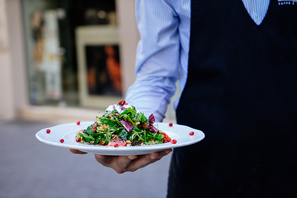 Serveur présentant une salade composée Envie des Mets pour la partie livraison de repas sur Nice d'Envie des mets